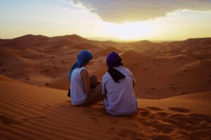 2 people looking over sand